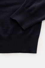 Stone Island Merino Crew Neck Sweater Navy shown from a close-up top-down view of sleeve and torso, pure merino wool, fine knit, slim fit, crew neck, compass badge on upper arm, ribbed cuffs and hem.