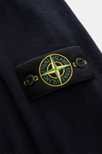 Close-up side view of the Stone Island Merino Crew Neck Sweater Navy showing pure merino wool knit and compass badge on upper arm. Timeless essential with iconic character: This STONE ISLAND crew neck sweater impresses with fine merino wool, an especially