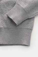 Nahaufnahme des Stone Island Rundhalspullover 'Maglia' grau, Detailansicht von Ärmel und Bund, reine Wolle, strukturierter Griff, Regular Fit.