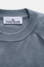 Stone Island Crew Neck Sweater 'Stretchwool' Smoky Blue shown from a close-up top front perspective, highlighting the ribbed crew neckline, fine knit pattern, and Stone Island label. Warming comfort with iconic character: This STONE ISLAND sweater combine