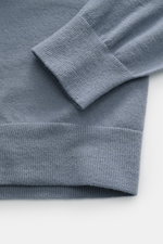 Close-up view of the ribbed cuff and hem of the Stone Island Crew Neck Sweater 'Stretchwool' Smoky Blue, showcasing fine knit pattern and soft texture.

Description: Warming comfort with iconic character: This STONE ISLAND sweater combines a high-quality 
