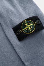 Close-up front detail of Stone Island Crew Neck Sweater 'Stretchwool' Smoky Blue showing soft virgin wool blend fabric and signature compass badge.

Description: <p>Warming comfort with iconic character: This STONE ISLAND sweater combines a high-quality w