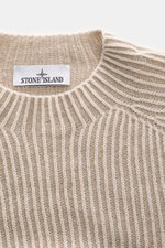 Nahaufnahme des Stone Island Wende-Rundhalspullovers "Vanise" beige/sand mit feinem Brioche-Strick und Logo-Etikett am Rundhalsausschnitt.
