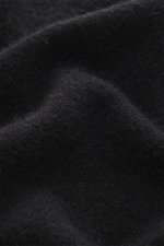 Nahaufnahme des Stone Island Rundhalspullover schwarz aus wärmendem Wollmix mit feinem Strickbild und Kompass-Badge am Ärmel.