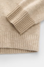 Stone Island Rundhalspullover beige meliert im Detail, Nahaufnahme der Ärmel und Rippsäume, wärmender Wollmix, weicher Griff, mittelfeines Strickbild.