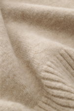 Nahaufnahme des Stone Island Rundhalspullover beige meliert aus wärmendem Wollmix mit weichem Griff und mittelfeinem Strickbild.