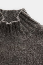 Nahaufnahme des taupefarbenen 04651/ A trip in a bag Mock Neck Pullover 'Grainy' mit hohem Rippstrickkragen, Boucléstrick und mittelfeinem Strickbild.