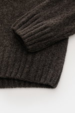 04651/ A trip in a bag Mock Neck Pullover 'Grainy' graubraun, Detailfoto von Ärmel und Saum aus wärmendem Woll-Mix Boucléstrick.
