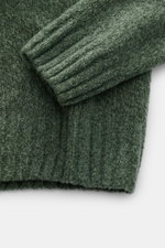 Grüne Nahaufnahme des 04651/ A trip in a bag Mock Neck Pullover 'Grainy' mit Boucléstrick, hohem Rippkragen und breiten Bündchen.