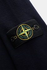 Close-up angled view of the Stone Island Crew Neck Sweater Navy showing the navy fine knit fabric and the signature compass badge on the upper arm. Warming comfort with iconic character: This STONE ISLAND sweater combines a high-quality wool blend with sp