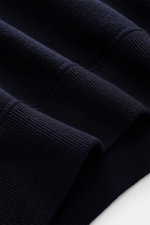 Close-up of the Stone Island Crew Neck Sweater Navy fabric and ribbed cuffs, photographed from a side angle showing fine knit pattern and texture. Warming comfort with iconic character: This STONE ISLAND sweater combines a high-quality wool blend with spo