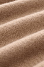Nahaufnahme eines hellbraunen Malo Cashmere Rundhalspullover-Stoffs mit feinem Strickbild, weichem Griff und Rippstruktur, Perspektive schräg von oben.