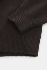 Malo Cashmere Rundhalspullover dunkelbraun mit mittelfeinem Strickbild, weichem Griff, Slim Fit, Rundhalsausschnitt und breiten Rippbündchen, Detail von Ärmel und Bund.