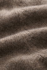 Nahaufnahme des strukturierten Strickbilds eines graubraun melierten Malo Cashmere Rundhalspullover, fotografiert aus schräger Perspektive.