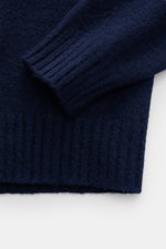 Nahaufnahme von Ärmel und Bund des Drumohr Rundhalspullover navy aus reiner, weicher Lammwolle, feinem Strickbild, Regular Fit, Rundhalsausschnitt und Rippbündchen, fotografiert von oben.
