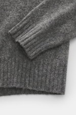 Close-up top-down view of Drumohr Crew neck sweater navy sleeve and ribbed cuff, showcasing pure lambswool and fine knit texture.