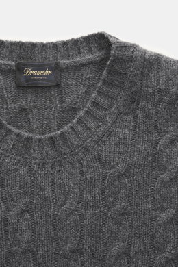 Nahaufnahme des Drumohr Cashmere Rundhalspullover dunkelgrau meliert mit klassischem Zopfstrickmuster, Rundhalsausschnitt und flexiblem Rippbündchen, fotografiert von oben.