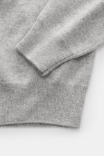 Close-up top-down view of the sleeve and bottom hem of the Fioroni Cashmere Crewneck Sweater grey melange, pure baby cashmere, very soft feel, fine knit pattern, slim fit, crew neckline, flexible ribbed cuffs.