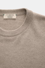 Close-up front view of Fioroni Cashmere Crewneck Sweater beige melange showing crew neckline, pure baby cashmere, very soft feel, fine knit pattern, slim fit, and flexible ribbed cuffs.