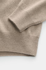 Close-up shot of the Fioroni Cashmere Crewneck Sweater beige melange sleeve and hem, showing pure baby cashmere, very soft feel, fine knit pattern, slim fit, crew neckline, and flexible ribbed cuffs.