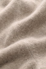 Close-up macro shot of the Fioroni Cashmere Crewneck Sweater beige melange fabric showing a fine knit pattern, pure baby cashmere, very soft feel, slim fit, crew neckline, and flexible ribbed cuffs.