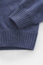 Close-up top-down view of the Gran Sasso Cashmere crew neck sweater smoky blue/dark blue melange showing sleeve and waistband details, pure cashmere, very soft feel, fine knit pattern, regular fit, crew neckline, comfortable ribbed cuffs.