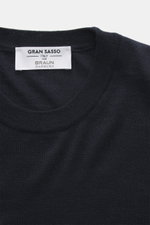 Close-up front top view of the Gran Sasso Fine-knit crew neck sweater navy showing crew neckline and label, made of mix of virgin wool, cashmere, and silk, with very soft feel, lightweight quality, very fine knit pattern, regular fit, and comfortable ribb