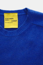 B.F. Knitwear Cashmere crew neck sweater blue shown from above, featuring a medium-fine knit, soft touch, slim fit, elastic ribbed cuffs, and crew neckline. Autumnal cashmere by B.F. KNITWEAR, durable and made in Italy.