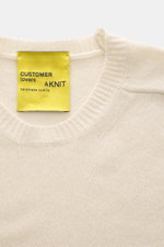 Close-up front view of B.F. Knitwear Cashmere crew neck sweater cream showing medium-fine knit, slim fit, elastic ribbed cuffs, and crew neckline, made of pure cashmere with a soft touch, durable and handmade quality from Italy.