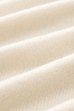 Close-up, angled view of B.F. Knitwear Cashmere crew neck sweater cream showing soft pure cashmere fabric, medium-fine knit, ribbed cuffs.