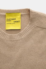 Close-up front view of B.F. Knitwear Cashmere crew neck beige sweater showing soft touch, medium-fine knit, and elastic ribbed cuffs.