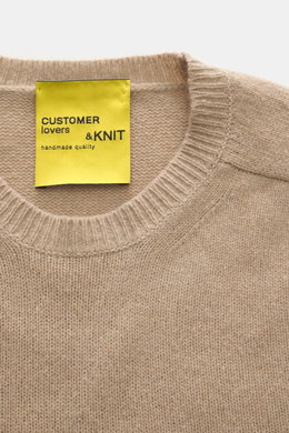 Close-up front view of B.F. Knitwear Cashmere crew neck beige sweater showing soft touch, medium-fine knit, and elastic ribbed cuffs.