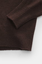 Close-up top-down view of B.F. Knitwear Cashmere crew neck sweater dark brown sleeve and body, showing medium-fine knit pattern and elastic ribbed cuffs.

Description:  
<p>Autumnal cashmere from the knitting expert B.F. KNITWEAR: This softly knitted crew