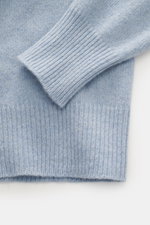 Nahaufnahme des B.F. Knitwear Cashmere Rundhalspullover hellblau meliert, Details von elastischem Rippstrick-Bündchen und mittelfeiner Strickstruktur, weich und langlebig, Slim Fit, italienische Herstellung.