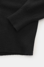 Close-up of B.F. Knitwear Cashmere crew neck sweater black showing elastic ribbed cuffs and medium-fine knit from top-down angle.