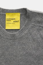 Close-up front view of B.F. Knitwear Cashmere crew neck sweater grey melange showing medium-fine knit, ribbed cuffs, and yellow label.

Description: <p>Autumnal cashmere from the knitting expert B.F. KNITWEAR: This softly knitted crew neck sweater is the 