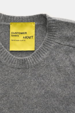 Close-up front view of B.F. Knitwear Cashmere crew neck sweater grey melange showing medium-fine knit, ribbed cuffs, and yellow label.

Description: <p>Autumnal cashmere from the knitting expert B.F. KNITWEAR: This softly knitted crew neck sweater is the 