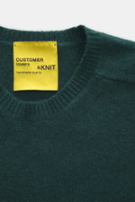 B.F. Knitwear Cashmere crew neck sweater dark green shown from above, medium-fine knit, slim fit, elastic ribbed cuffs, pure cashmere, soft touch.