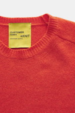 Close-up front view of B.F. Knitwear Cashmere crew neck sweater orange showing medium-fine knit, elastic ribbed cuffs, and crew neckline, made of pure soft cashmere. Autumnal cashmere from the knitting expert B.F. KNITWEAR: This softly knitted crew neck s