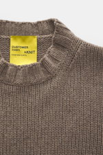 Close-up top-down view of the B.F. Knitwear Cashmere crew neck sweater taupe showing medium coarse knit, elastic ribbed cuffs, and crew neckline, pure cashmere, soft touch, regular fit, handmade in Italy. Autumnal cashmere from the knitting expert B.F. KN