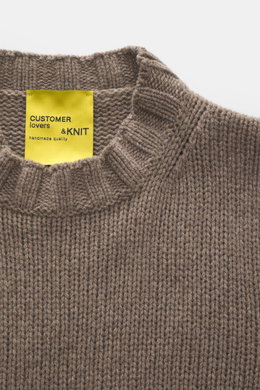 Close-up top-down view of the B.F. Knitwear Cashmere crew neck sweater taupe showing medium coarse knit, elastic ribbed cuffs, and crew neckline, pure cashmere, soft touch, regular fit, handmade in Italy. Autumnal cashmere from the knitting expert B.F. KN