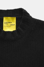 Close-up front view of B.F. Knitwear Cashmere crew neck sweater black showing medium coarse knit pattern and elastic ribbed cuffs, made in Italy with pure cashmere and soft touch, perfect for autumn.
