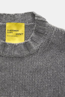Close-up top-down view of the B.F. Knitwear Cashmere crew neck sweater grey melange showing the soft, medium knit texture and elastic ribbed crew neckline with a yellow label. Autumnal cashmere by knitting expert B.F. KNITWEAR: This softly knitted crew ne
