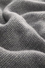 Close-up front view of B.F. Knitwear Cashmere crew neck sweater grey melange showing soft pure cashmere medium knit texture with elastic ribbed cuffs.