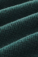 Close-up angled view of dark green B.F. Knitwear Cashmere crew neck sweater showing textured medium coarse knit pattern and soft touch.