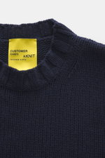 Close-up top view of B.F. Knitwear Cashmere crewneck sweater navy showing medium knit texture, crew neckline, and yellow label.