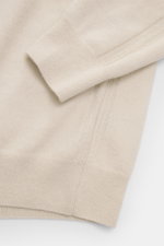 Nahaufnahme des Colombo Cashmere Rundhalspullover sand mit weichem Griff, Rundhalsausschnitt, seitlicher Strukturstrick-Borte und Rippbündchen, fotografiert von oben schräg. Subtiler Luxus aus reinem Yangir Cashmere, Regular Fit.