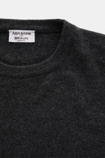 Close-up front view of Aida Barni Cashmere crew neck jumper dark grey melange showing fine knit, ribbed crew neckline, and label.

<p>Luxury-class essential: The Italian label AIDA BARNI processes premium cashmere in this timeless crewneck sweater with a 