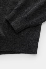 Close-up top-down view of Aida Barni Cashmere crew neck jumper dark grey melange sleeve and hem showing fine knit, ribbed cuffs, and soft cashmere texture.