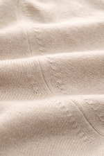 Close-up fabric texture of the Aida Barni Cashmere crew neck jumper sand melange, photographed from a top-down angle, showcasing pure cashmere, soft feel, fine knit pattern, regular fit, crew neckline, and ribbed cuffs.